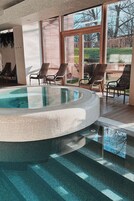 Una piscina techada, sillones reclinables de piscina