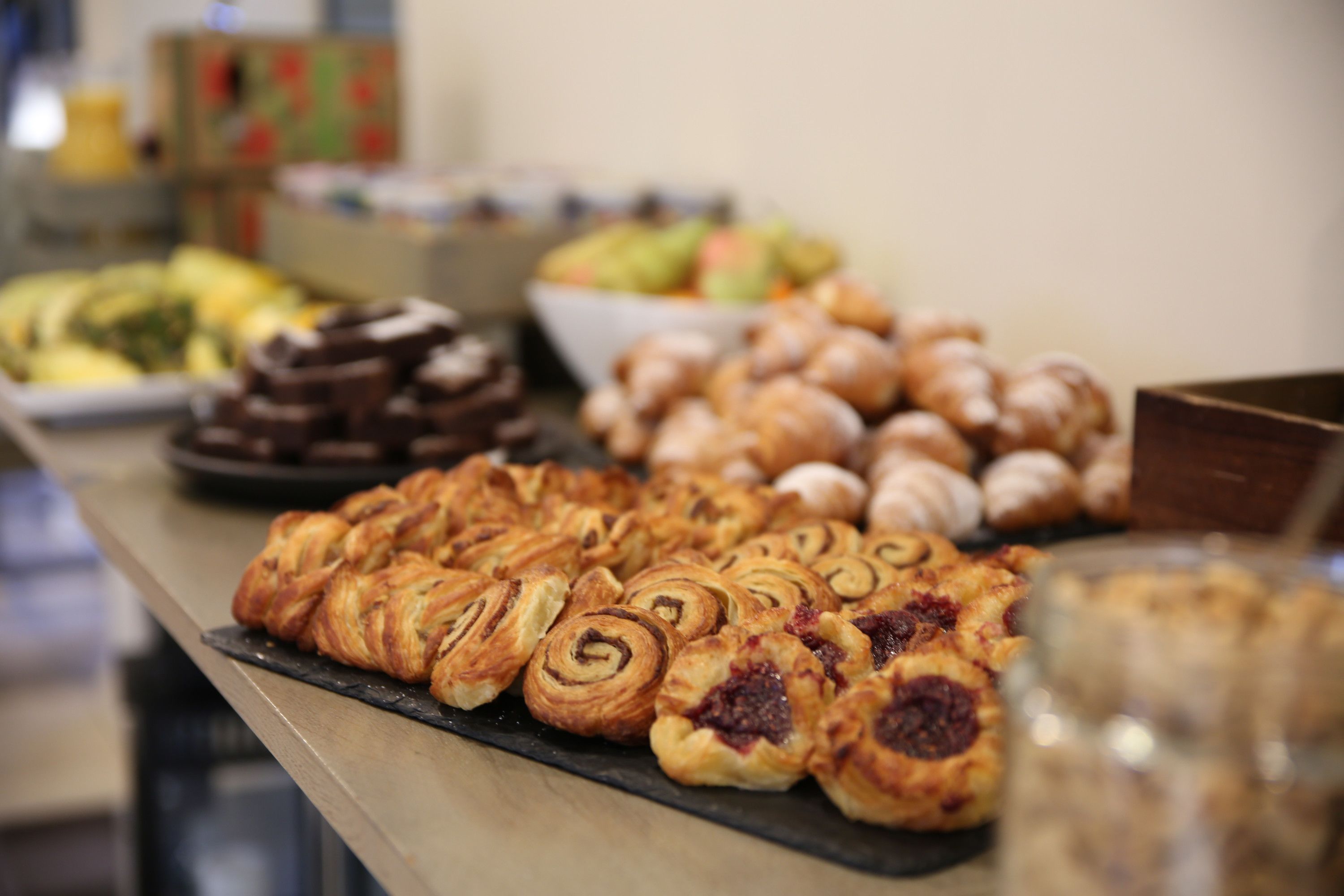 A buffet table with various pastries and desserts.