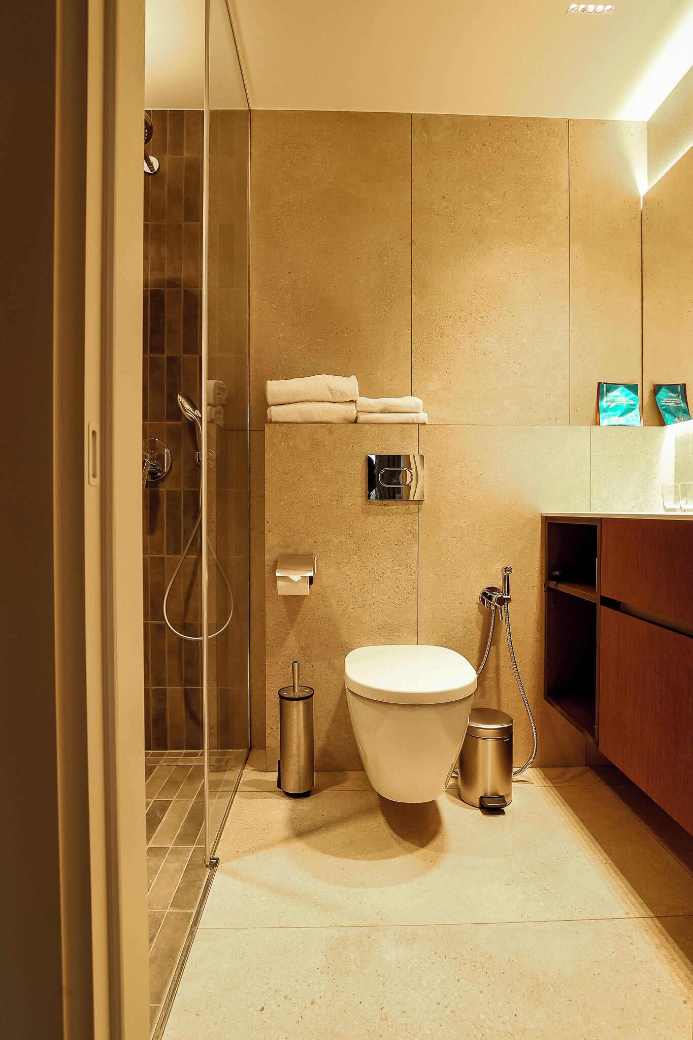 Un baño moderno con ducha de vidrio, inodoro y lavamanos.