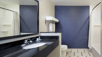 A modern bathroom with a black sink, a mirror, a white toilet, and a shower curtain.