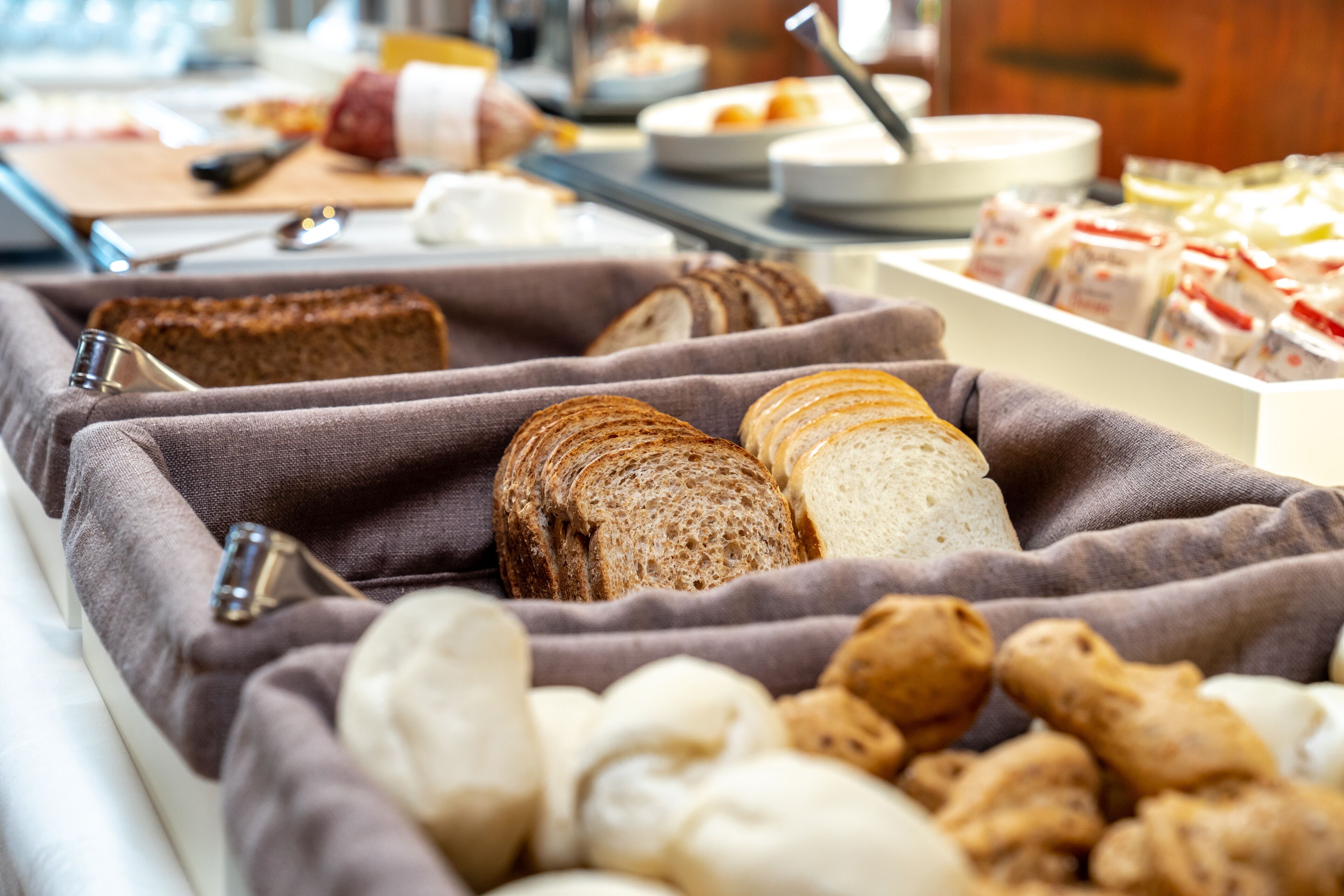 A buffet with various breads and pastries.