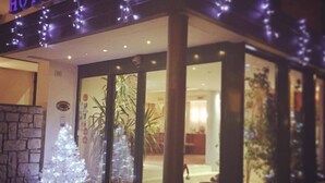 A hotel entrance with a sign reading "HOTEL DIANA" and a Christmas tree outside. - Hotel Diana (Valdobbiadene)