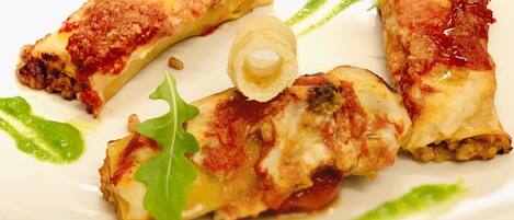 Un plato con alimentos, decorado con hojas verdes y salsa.
