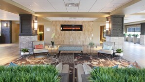 A spacious lobby with a central seating area, a fireplace, and a modern design.