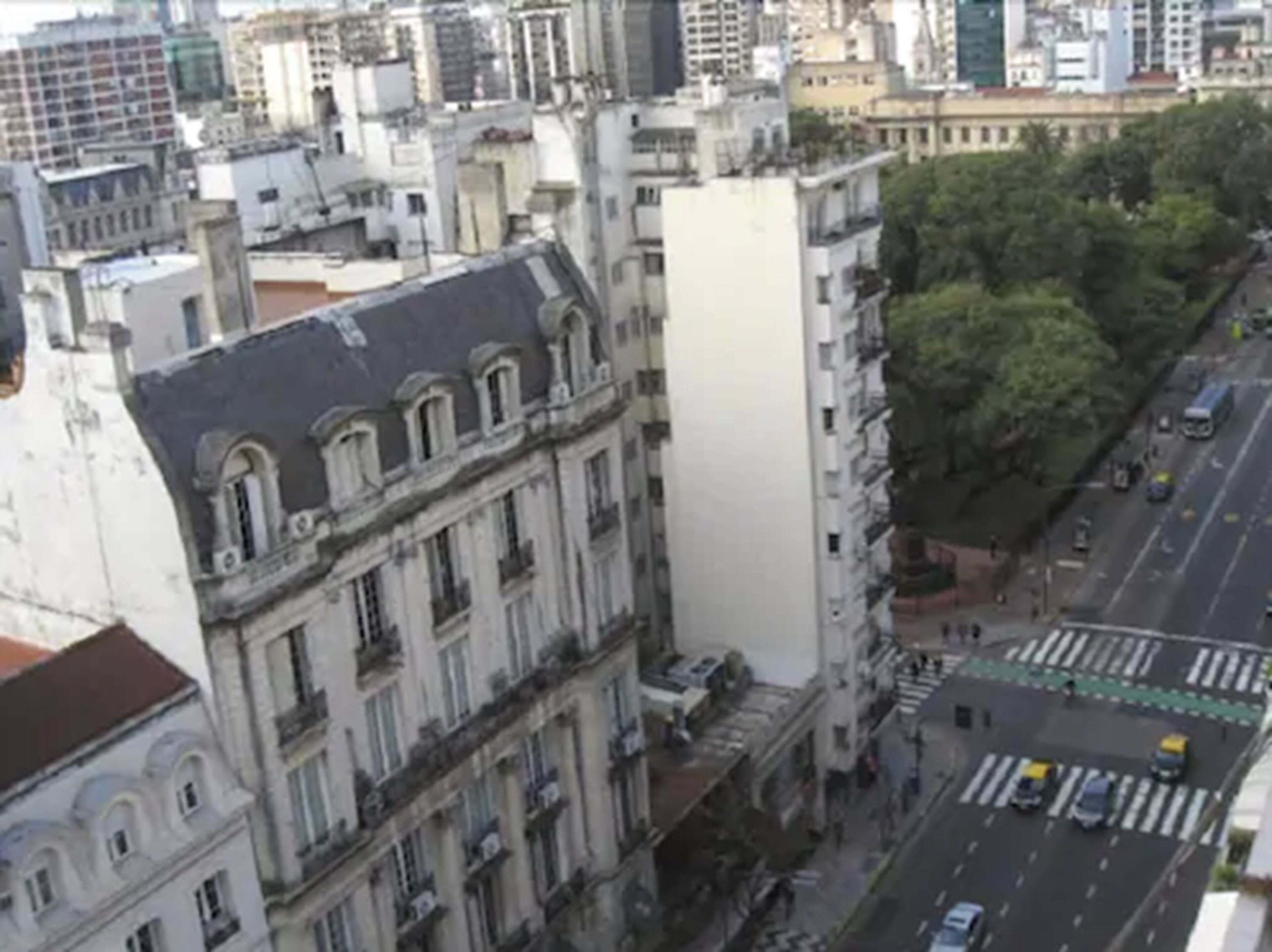 Un edificio alto de estilo arquitectónico clásico, con múltiples ventanas y balcones.
