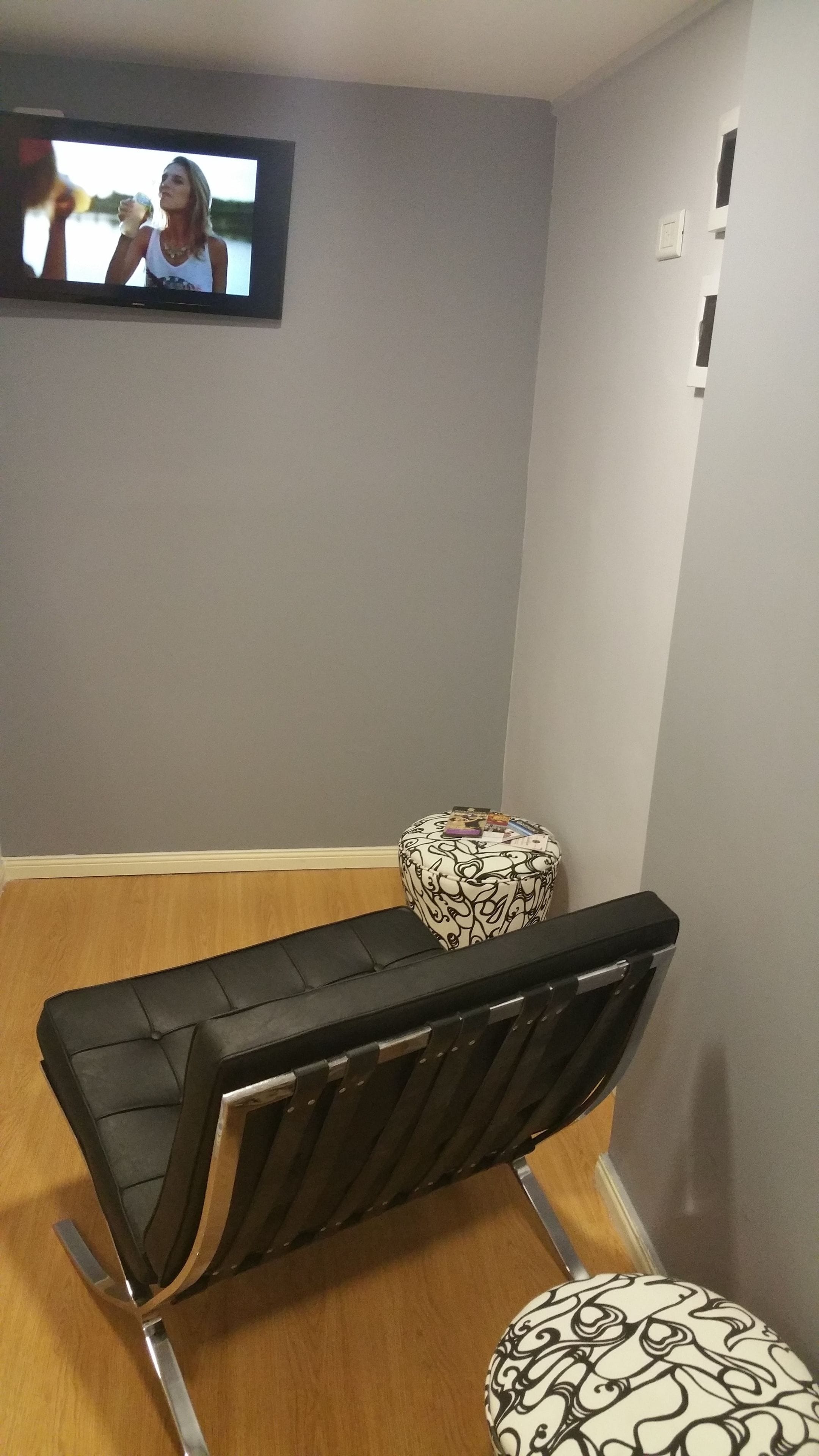 Huoneessa on hierontapöytä, pieni jalkarahikka ja seinälle asennettu televisio.