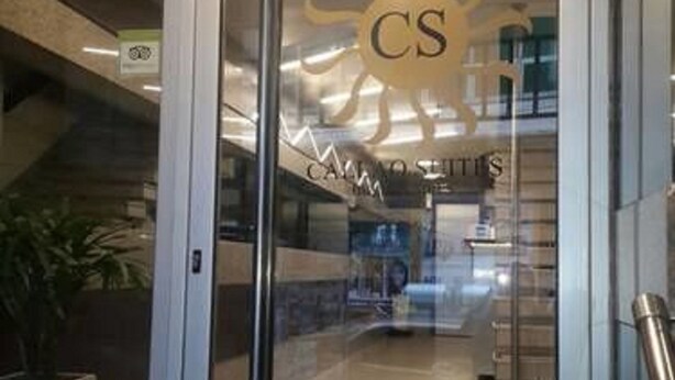 Una puerta de vidrio con un logotipo y el nombre "CAMPOS STUDIO" visible en el interior.