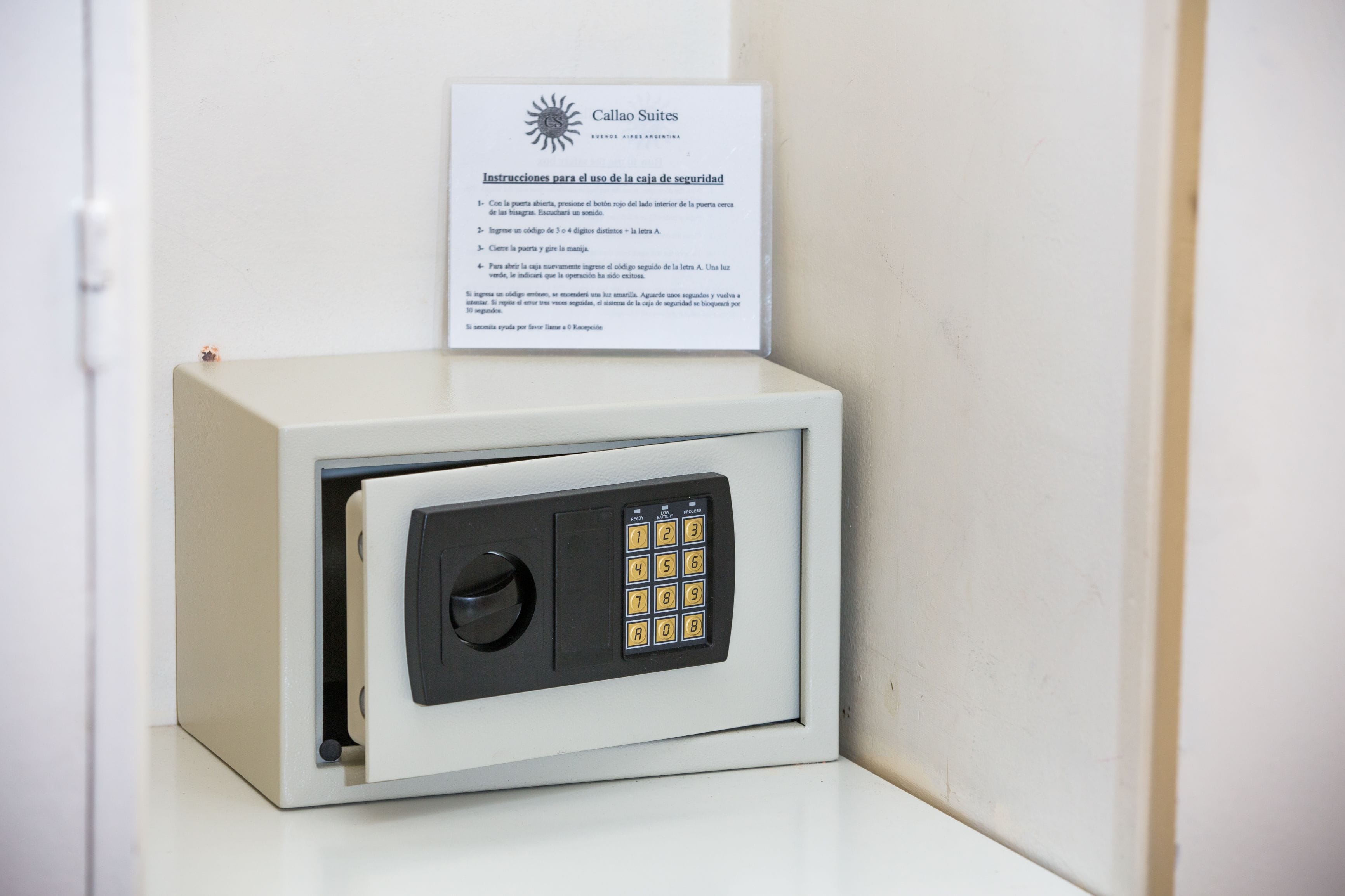 A safe with a keypad lock and a sign with instructions for use.