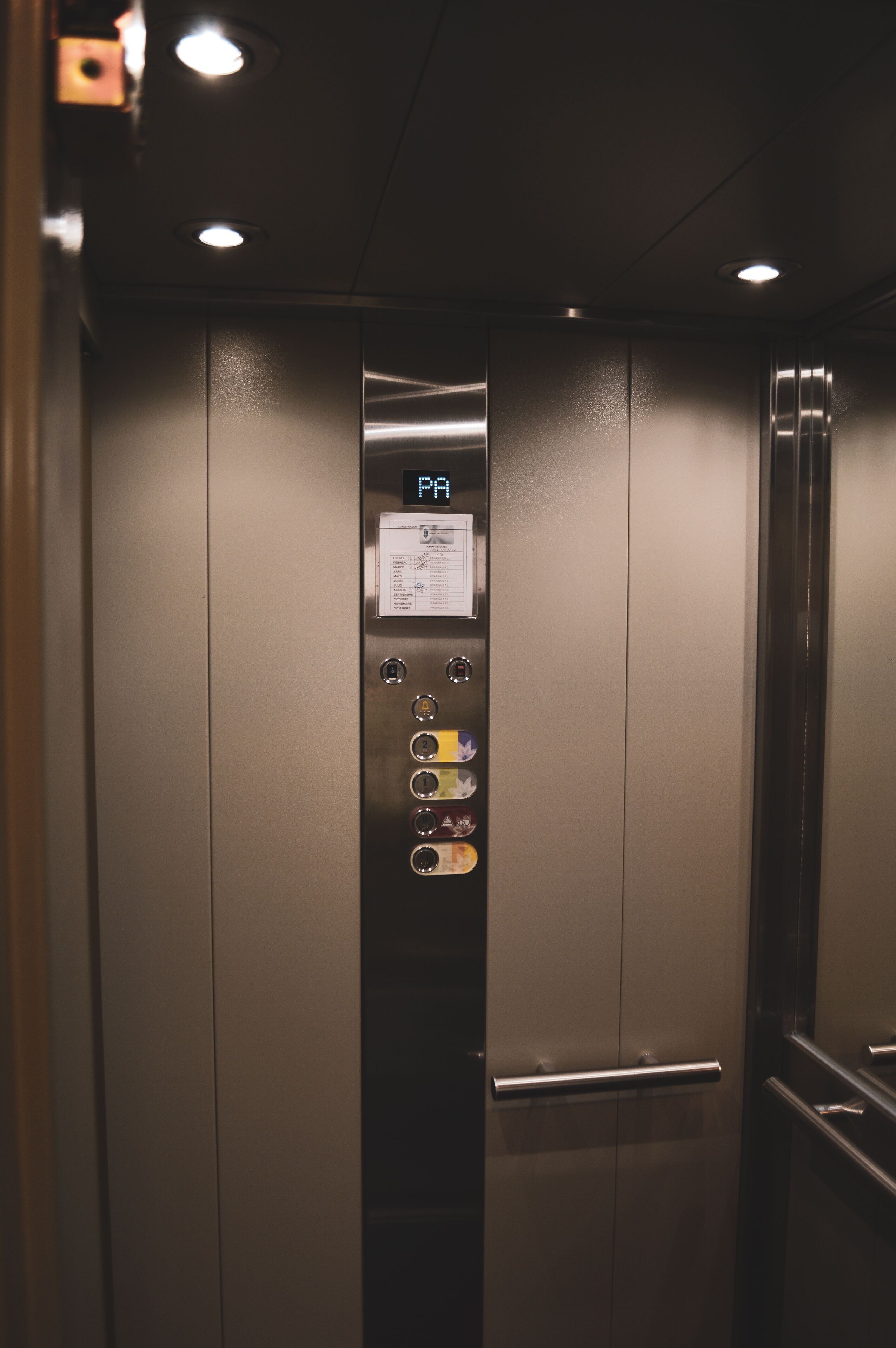 An elevator interior with a digital display, control buttons, and a card reader.