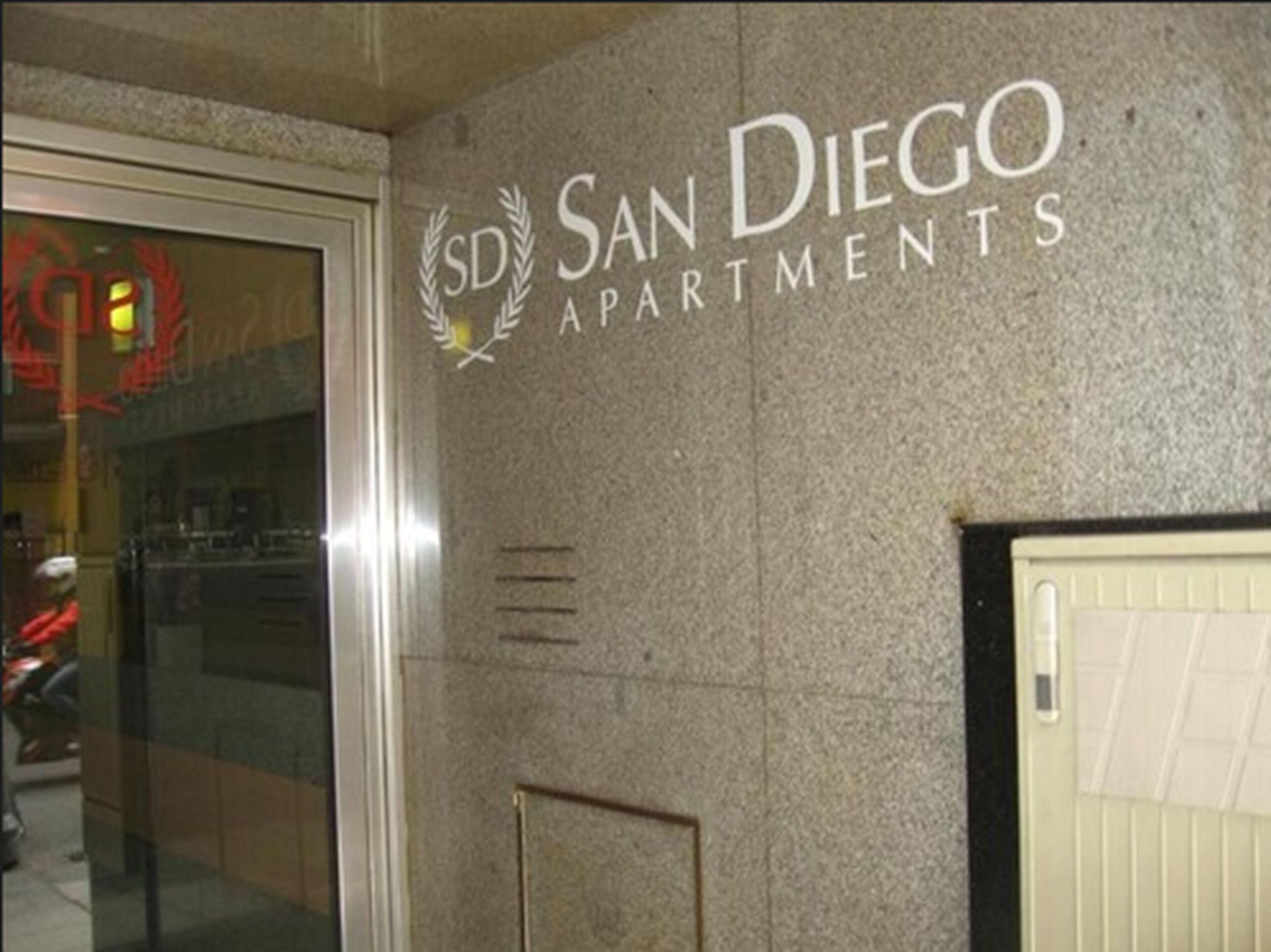 Fachada de un edificio con el texto "SD San Diego Apartments" y un logotipo.