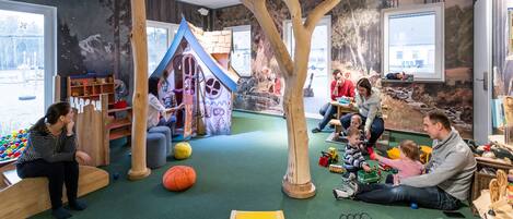 Une salle de jeux avec un toboggan, des structures de jeu et des jouets.
