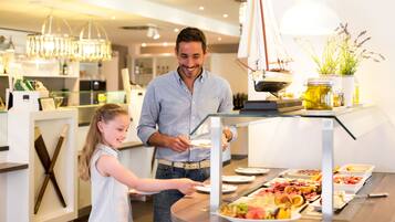Ein Buffet mit verschiedenen Speisen und einer Segelboot-Dekoration im Hintergrund.