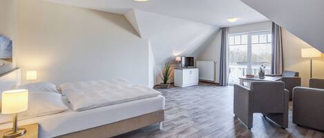 A modern hotel room with a bed, bedside lamps, a desk, and a chair.