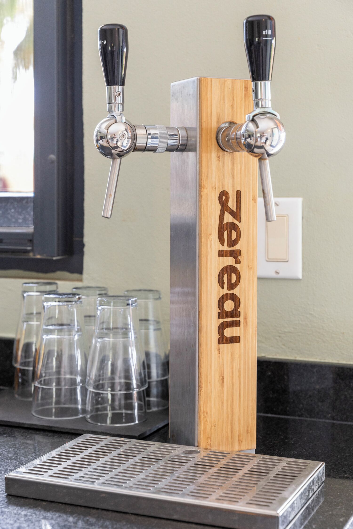 A tap with a wooden base labeled 'Zereau' and a metal drip tray below it.