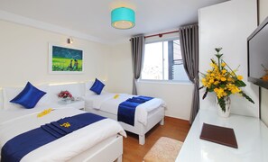 Ein Hotelzimmer mit zwei Betten, einem Schreibtisch, einem Stuhl, einem Gemälde, einem Fenster mit Vorhängen und einer Vase mit Blumen.