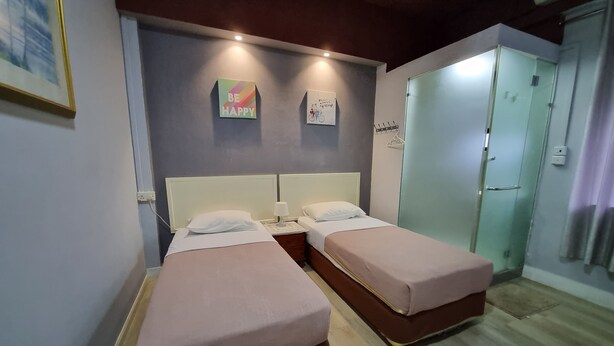 A room with two beds, a wardrobe, and a mirror. - Lavender Lodge (Kota Kinabalu)