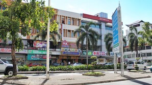 A multi-story commercial building with various storefronts, including a bank, a restaurant, and a local produce shop. - Lavender Lodge (Kota Kinabalu)