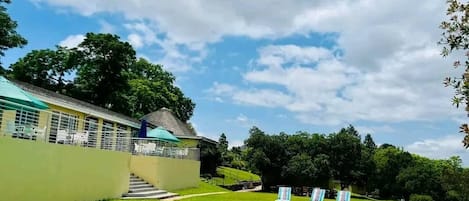 Una piscina al aire libre, sillones reclinables de piscina