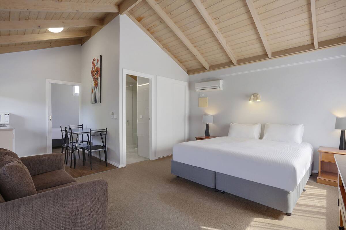 Ein Schlafzimmer mit Bett, Nachttischen, Schreibtisch und Stuhl.