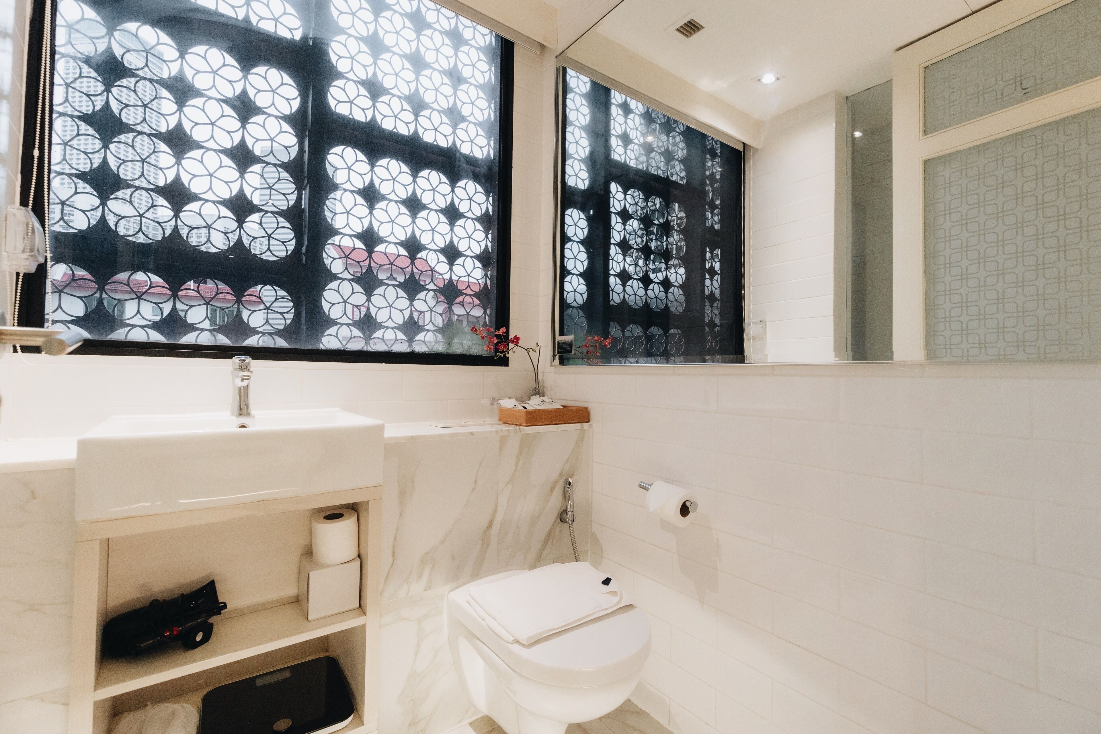 A modern bathroom with a toilet, sink, and shower.