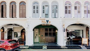 A hotel with a classic facade, multiple windows with shutters, and a prominent entrance. - Hotel NuVe Heritage (Singapore)