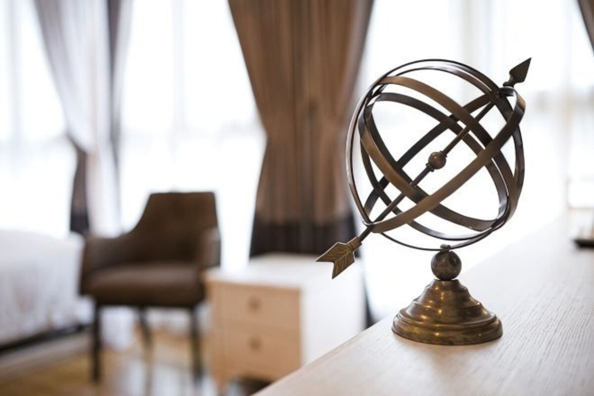 Un globo sobre una mesa de madera en una habitación de hotel, con una cama y una silla al fondo.