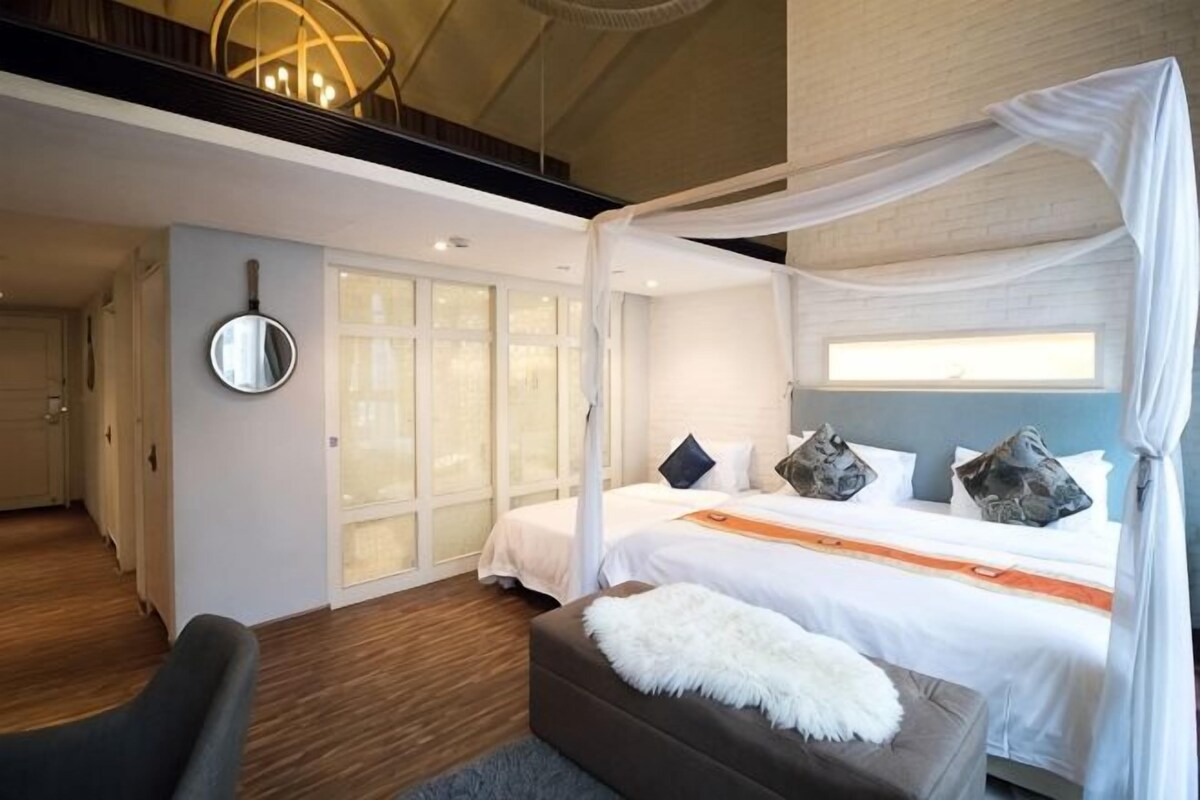 Un dormitorio con cama con dosel, un espejo grande y vestidor.
