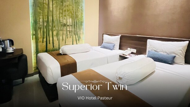 Habitación de hotel con dos camas, una mesita de noche y un cuadro de bambú.