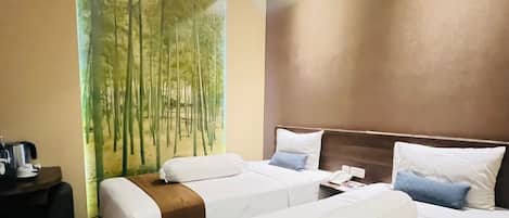 A hotel room with two beds, a nightstand, and a painting of bamboo.