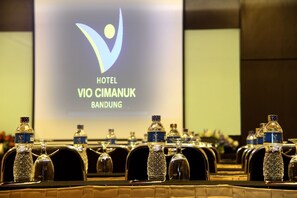 Hotel Vio Cimanuk Bandung conference room features a large screen and rows of chairs for formal meetings.