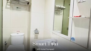 Une salle de bain équipée de toilettes, d’un lavabo et d’un porte-serviettes.