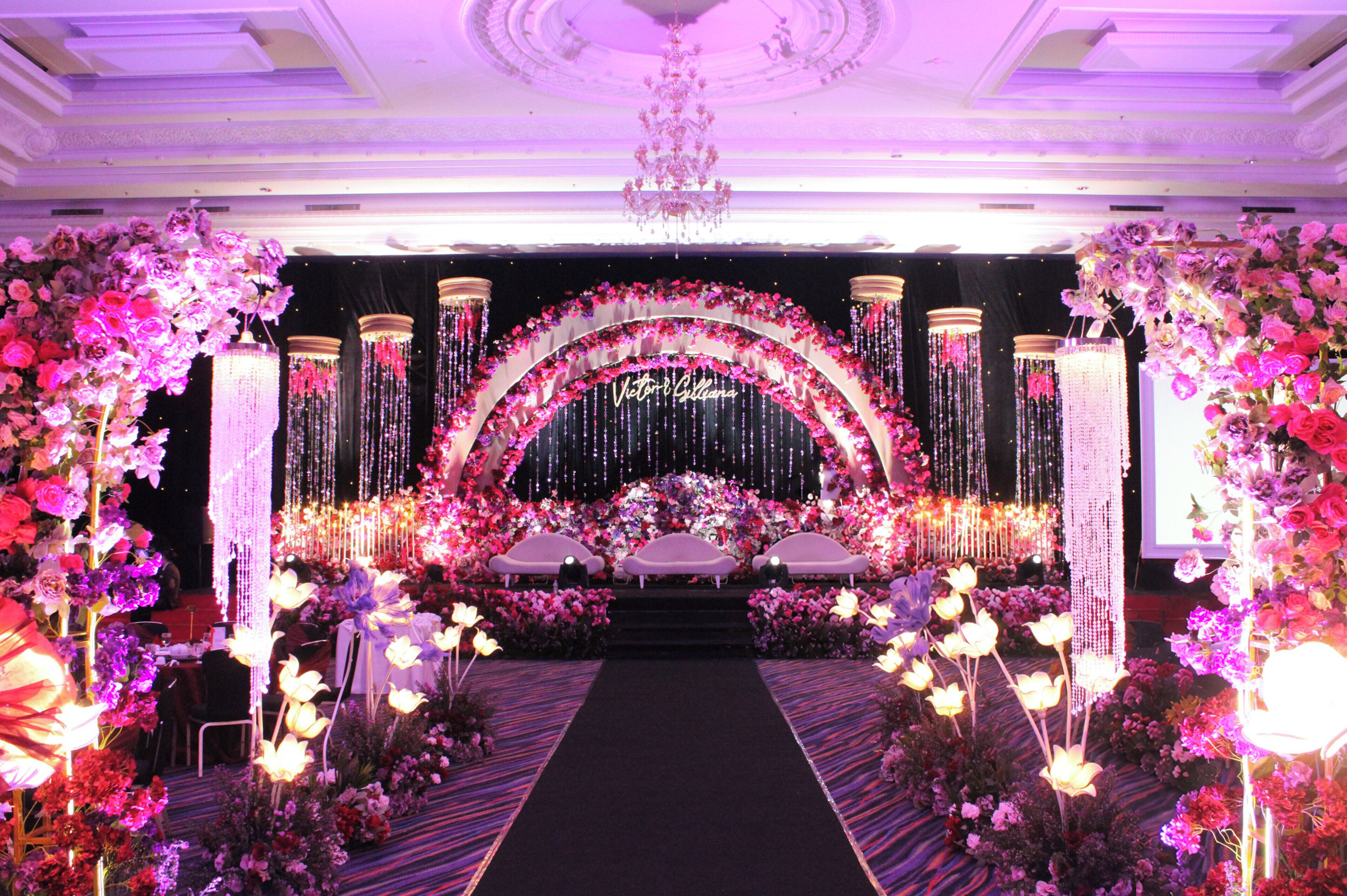 A stage with floral decorations and a chandelier.