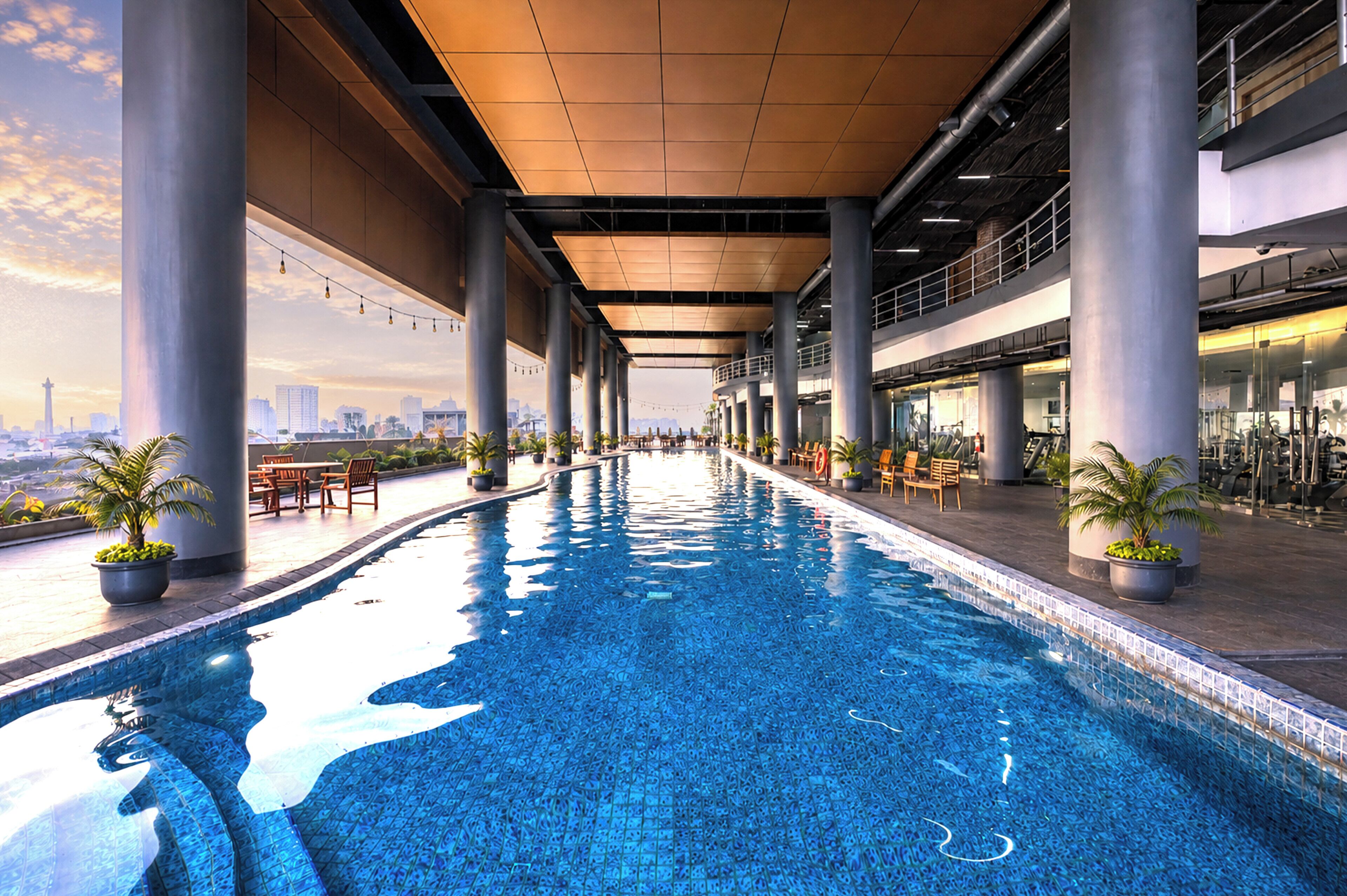 Una piscina cubierta, una piscina al aire libre, tumbonas
