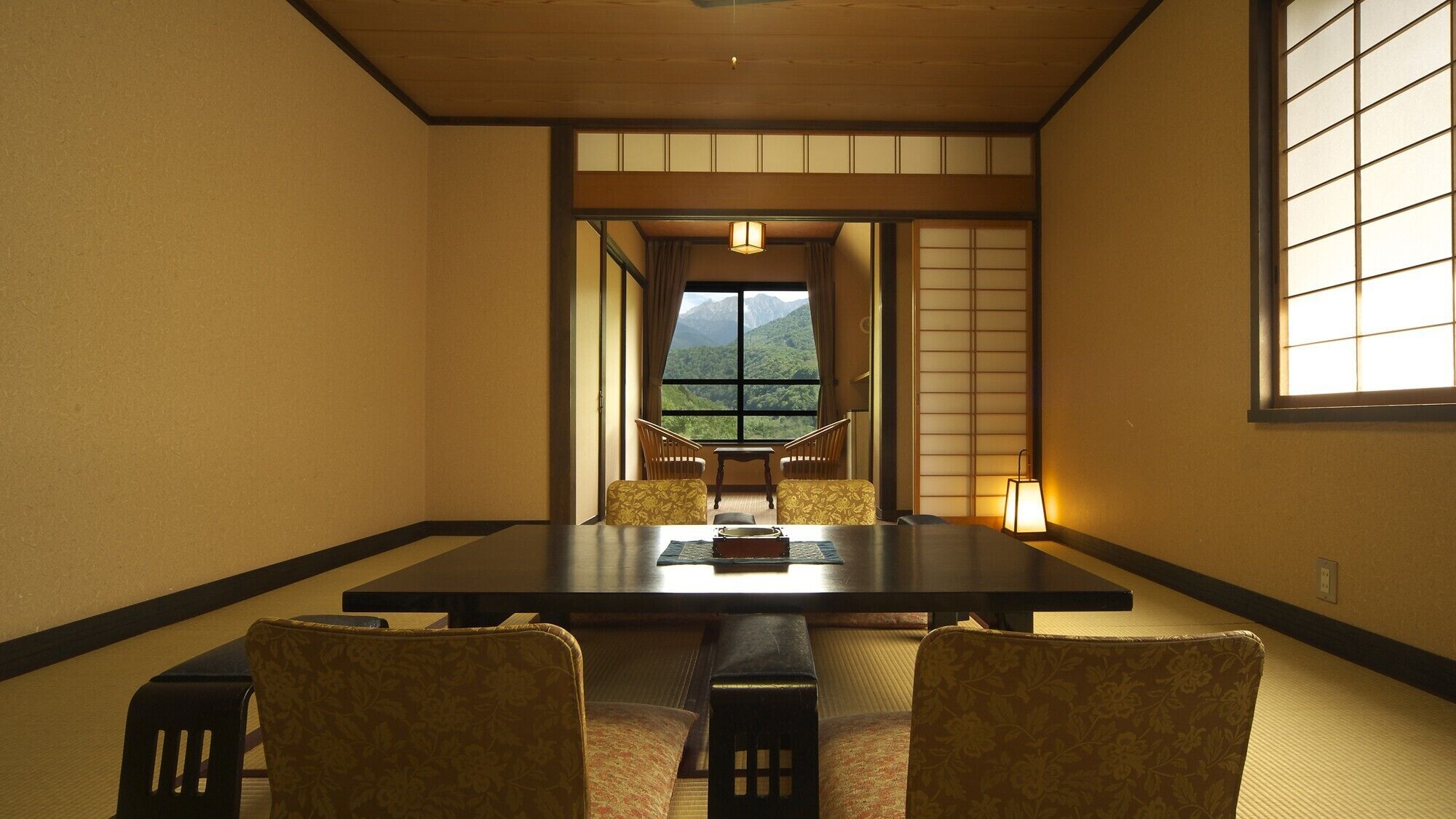 Une pièce de style japonais traditionnel, avec un sol recouvert de tatamis, une table basse et des paravents en papier de riz (shoji).