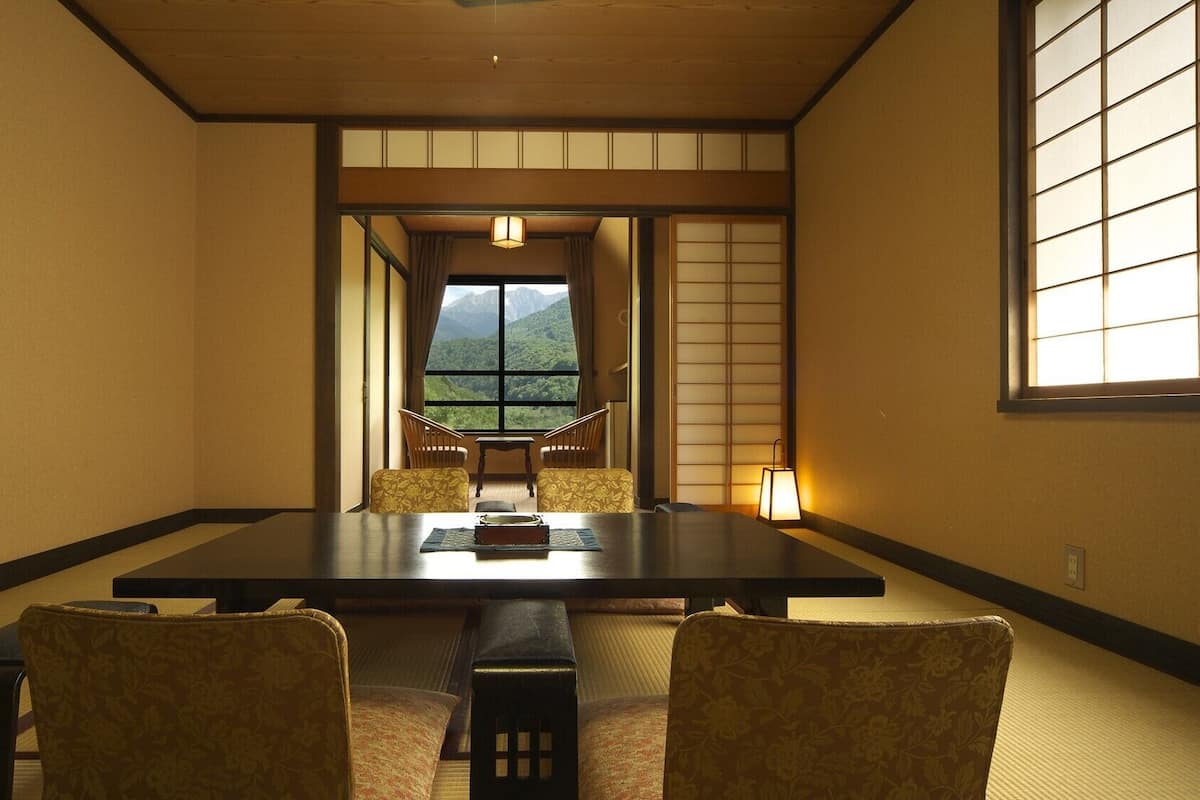 Une pièce de style japonais traditionnel, avec un sol recouvert de tatamis, une table basse et des paravents en papier de riz (shoji).
