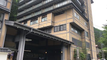 A multi-story building with a modern architectural design, featuring a covered entrance and a visible staircase.