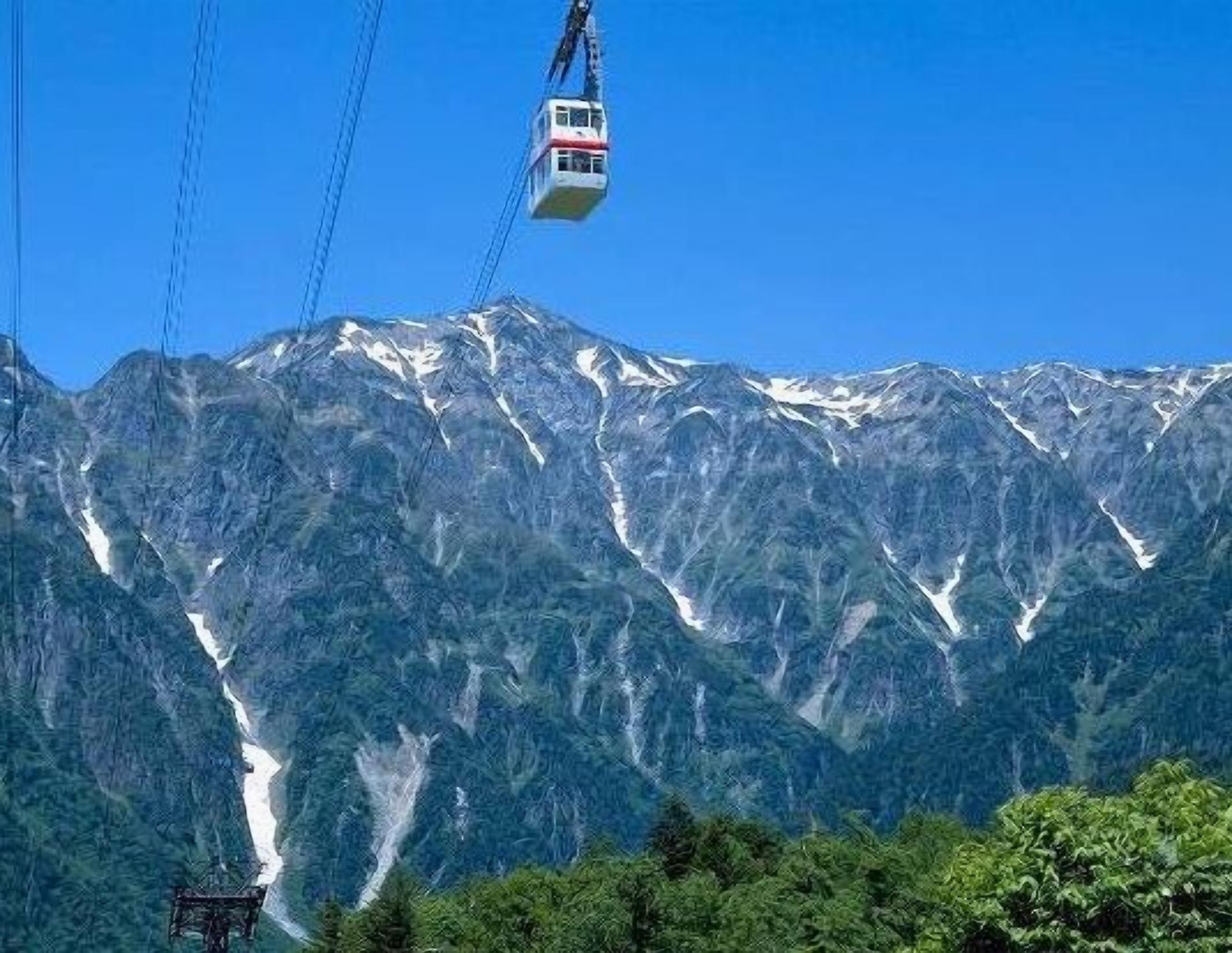 Un teleférico avanza sobre un paisaje montañoso con picos nevados.
