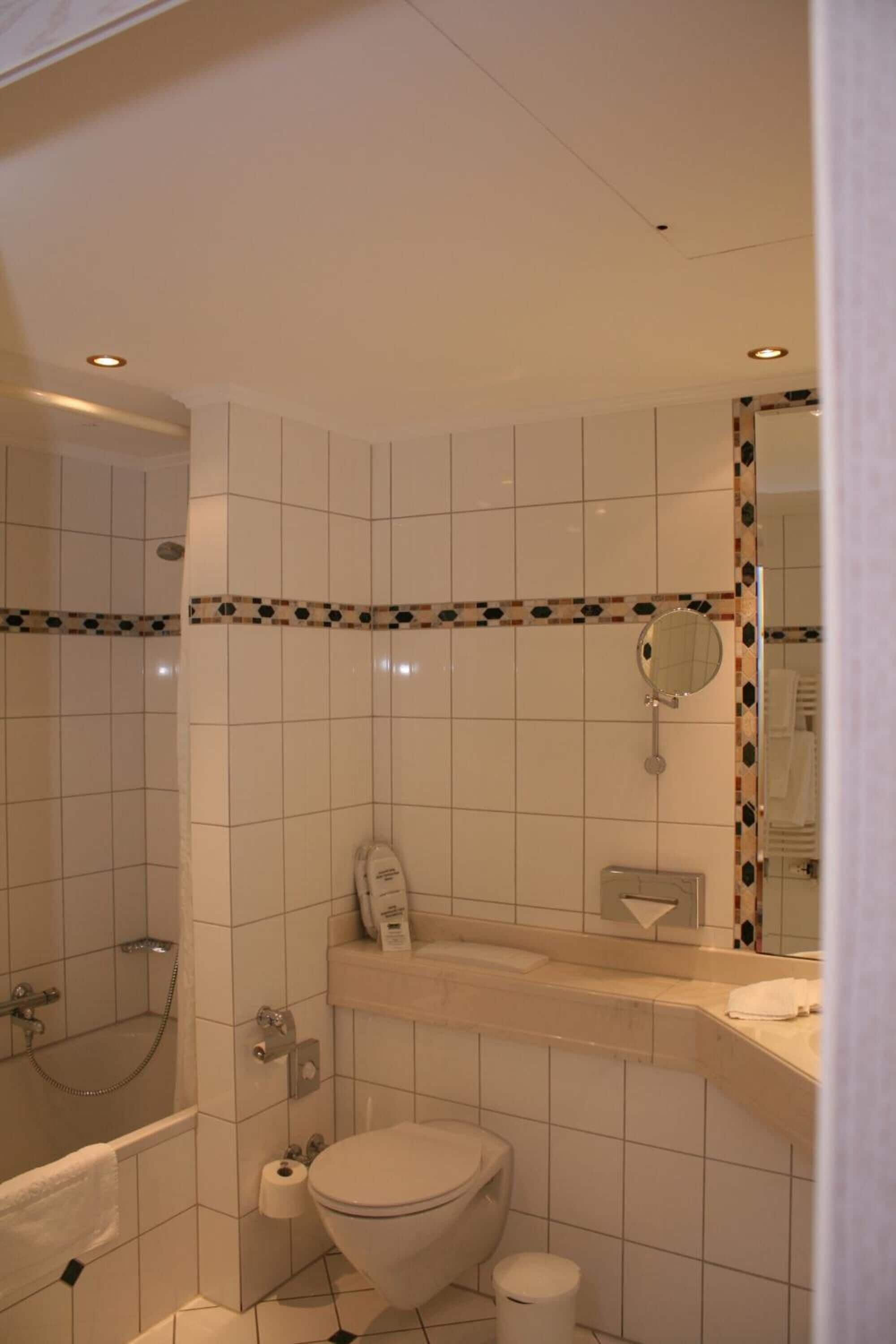 A bathroom with a toilet, a shower, and a sink.