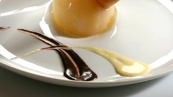 Ein Dessert auf einem Teller mit Schokoladen- und Vanillesauce.