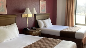 A hotel room with two beds, a nightstand with lamps, and a window with curtains.