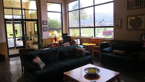 A spacious room with large windows, a sofa, a coffee table, and a door marked "EXIT".