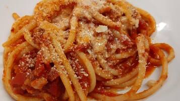 A plate of spaghetti with tomato sauce and grated cheese.