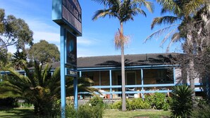 A building with a blue exterior and a sign indicating it is a village hotel. - Balnarring Village Motor Inn (Balnarring)