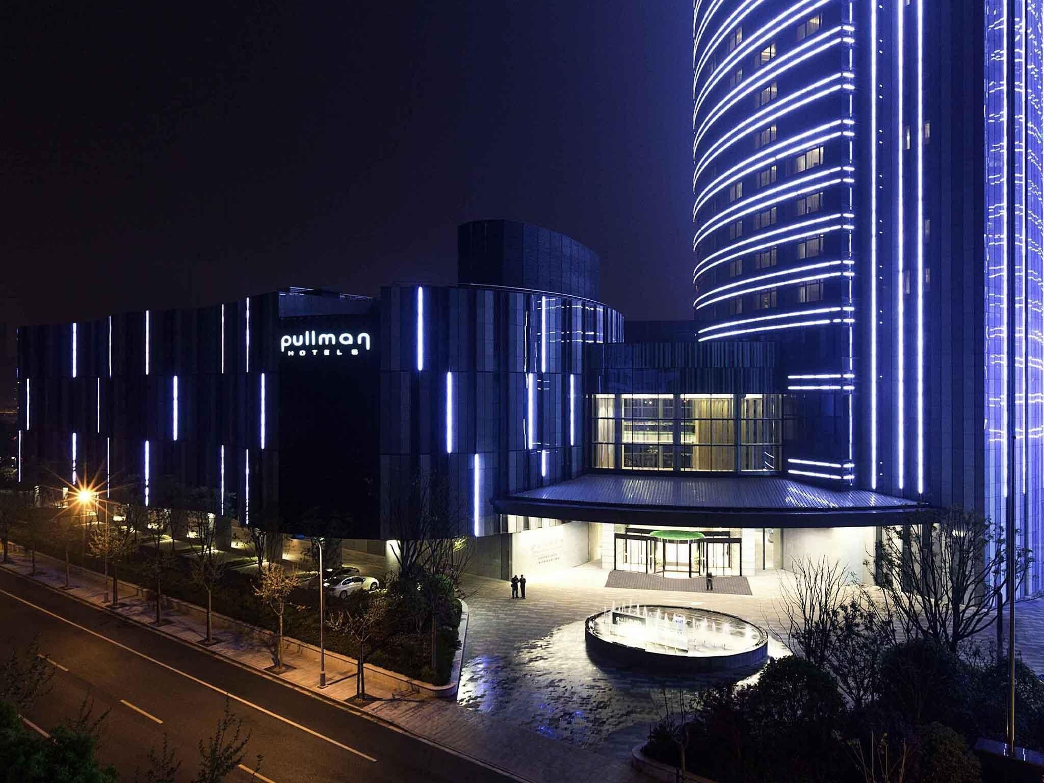 Un hotel de diseño moderno, con un edificio curvo destacado y una entrada bien iluminada.