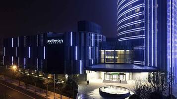 Un hotel de diseño moderno, con un edificio curvo destacado y una entrada bien iluminada.