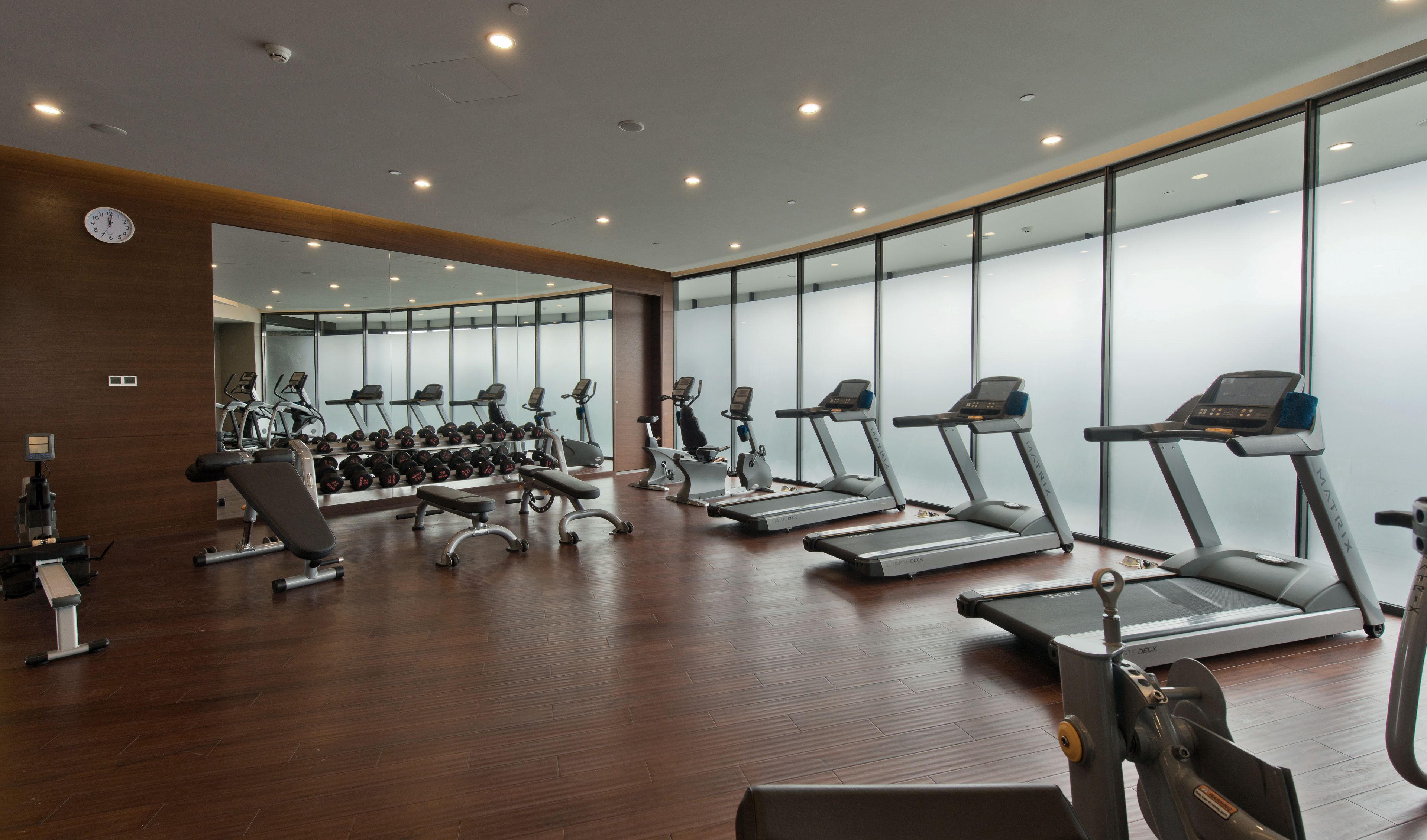 Une salle de sport équipée de tapis de course, d’haltères et d’autres appareils d’exercice.