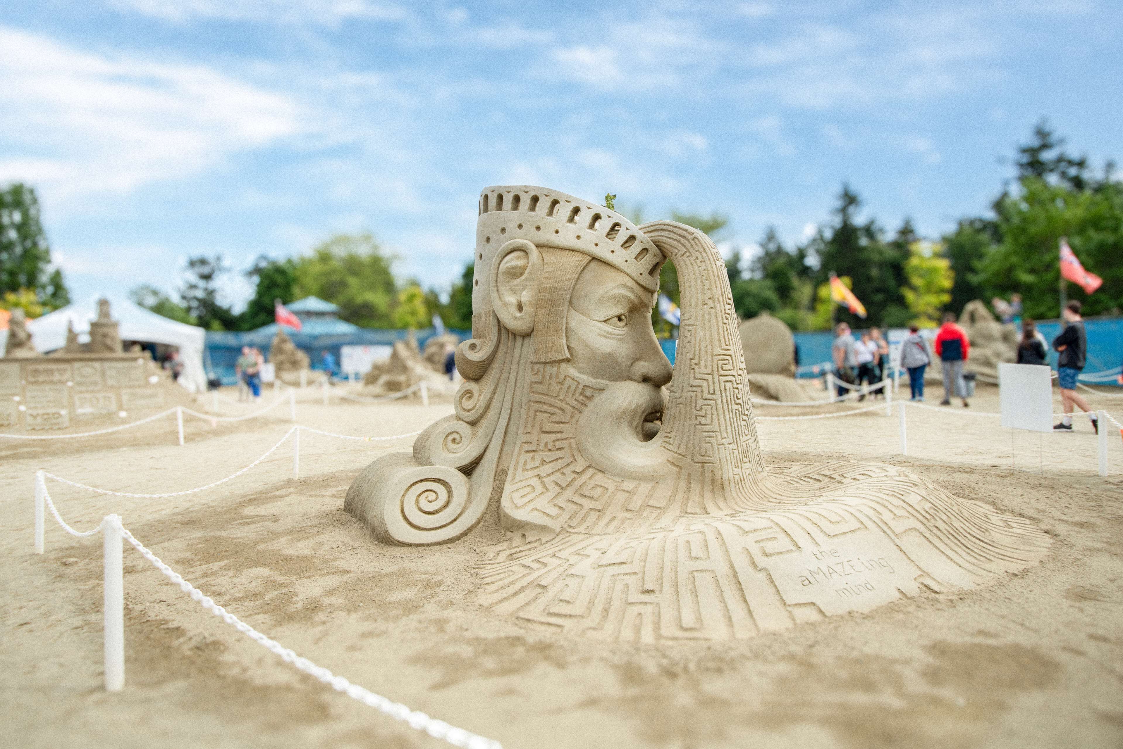 Une sculpture de sable représentant une figure couronnée, avec un serpent.