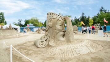 Une sculpture de sable représentant une figure couronnée, avec un serpent.