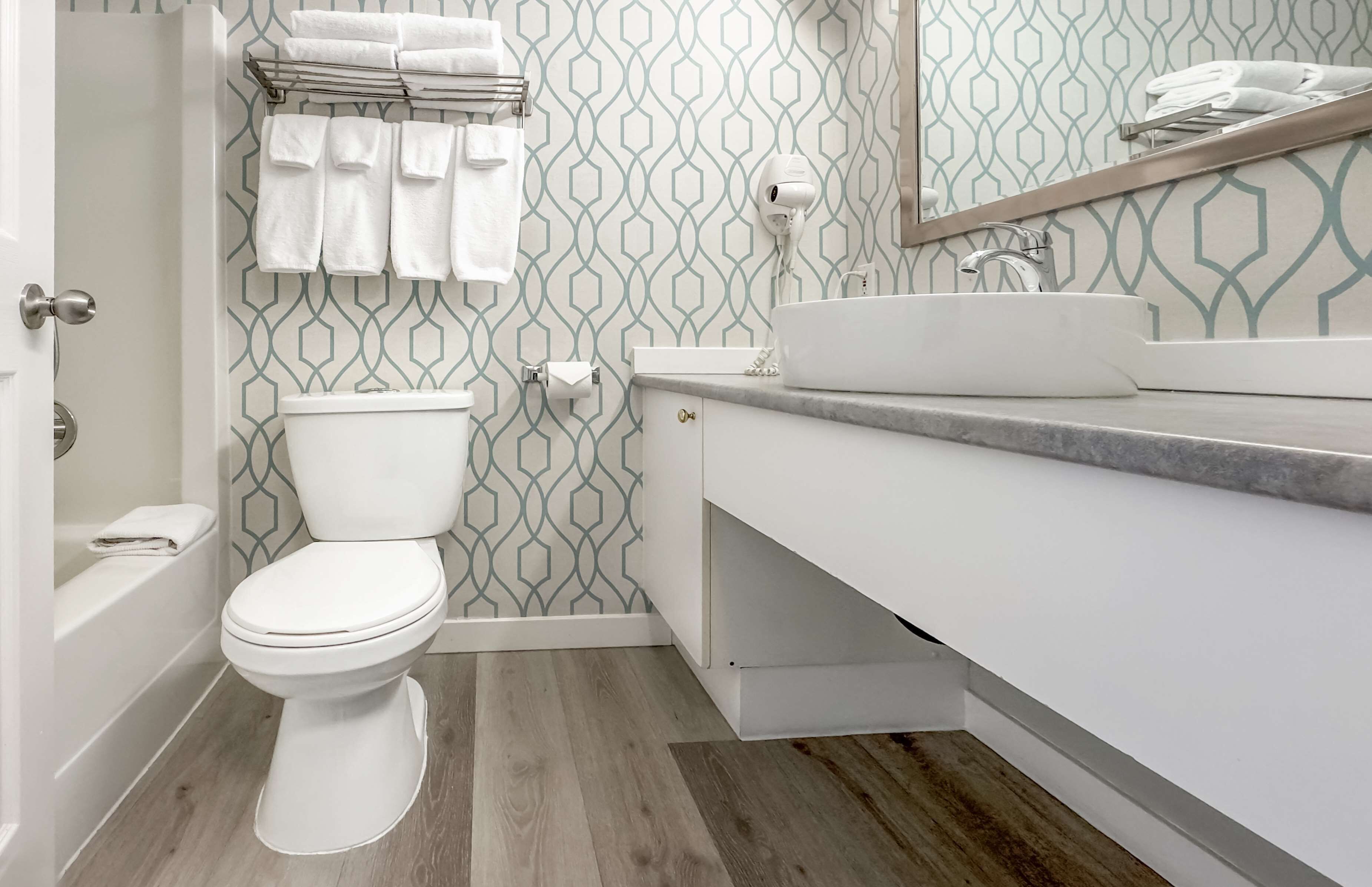 A modern bathroom with a toilet, sink, and shower.