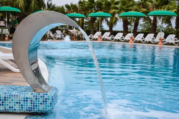 Alberca al aire libre por temporada y sombrillas en la alberca